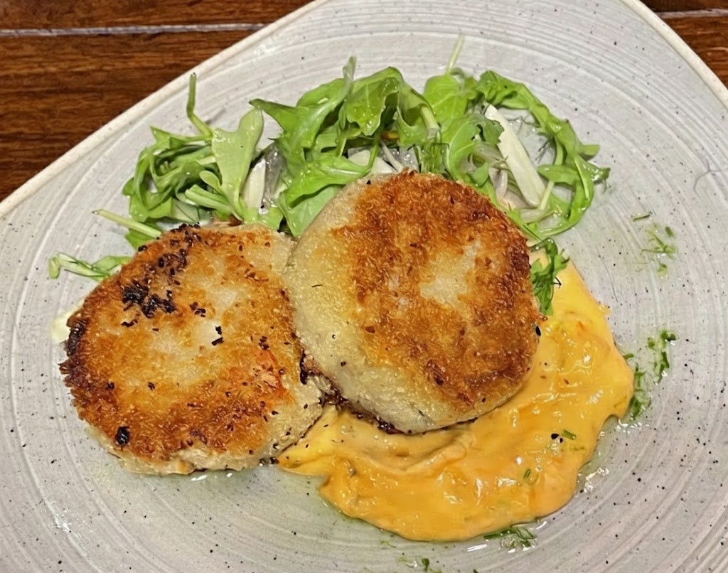 黄色いソースの上に乗ったクラブケーキの写真